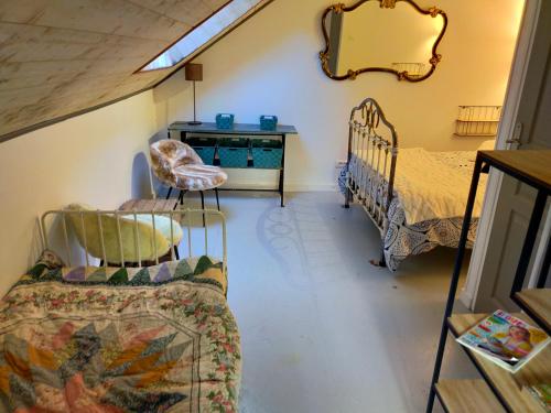 a living room with two beds and a dresser at L'éléphant Blanc de ConcarnOLoc in Concarneau