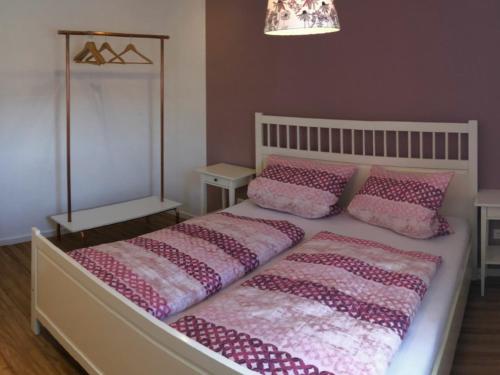 um quarto com uma cama grande e almofadas cor-de-rosa em Ferienwohnung Morgensonne em Kenzingen