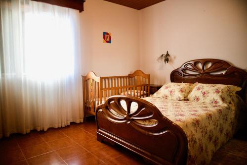 1 dormitorio con 1 cama, 2 cunas y ventana en Rosinha Country House en Vale de Cambra