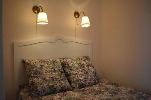 阿卡雄Cosy 2 Pièces Moulleau Centre à deux pas de la Plage的一间卧室,床上方有两盏灯