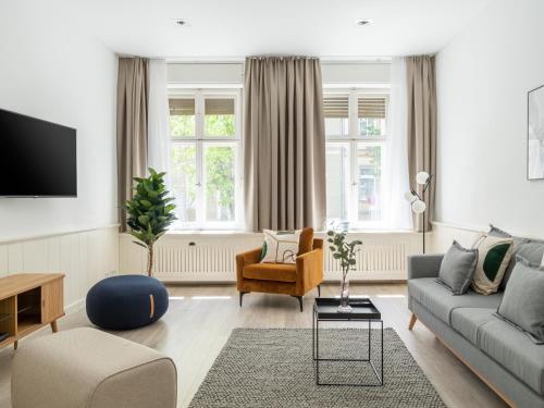 een woonkamer met een bank en een stoel bij Apartments Berlin Lottumstraße 4 in Berlijn