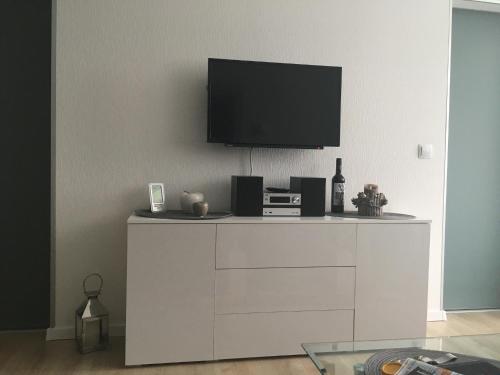 uma sala de estar com televisão numa cómoda branca em Lubeca em Hahnenklee-Bockswiese