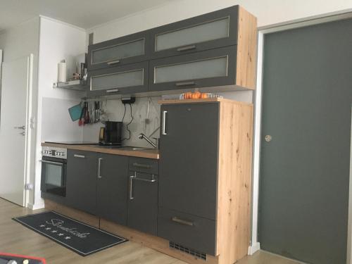 eine Küche mit schwarzen Schränken und einem schwarzen Kühlschrank in der Unterkunft LUBECA - a49948 in Hahnenklee-Bockswiese
