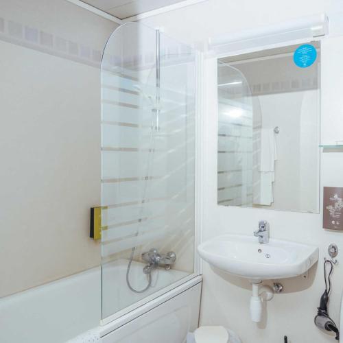 a white bathroom with a sink and a shower at Utsikten Hotell Kvinesdal - Unike Hoteller in Kvinesdal