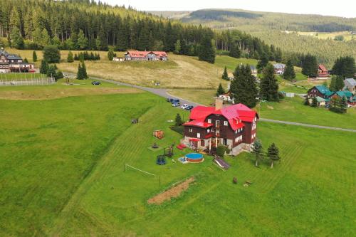 an aerial view of a large house on a green field at Penzion Logla in Pec pod Sněžkou