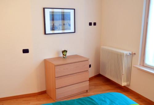 a bedroom with a dresser and a picture on the wall at Il Vicolo in Como