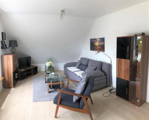 ein Wohnzimmer mit einem Sofa und einem Tisch in der Unterkunft Bootshaus, App 4 in Grömitz