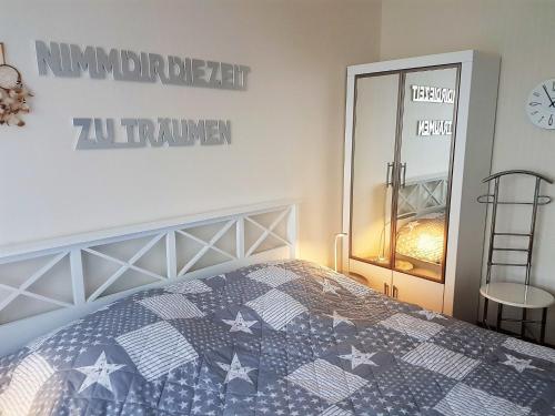 a bedroom with a blue and white bed and a mirror at Wiking Whg 5 in Grömitz