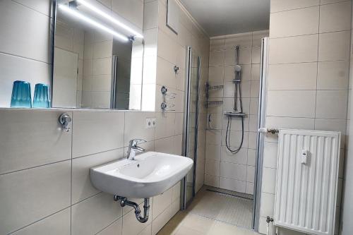 a white bathroom with a sink and a shower at Residenz "Am Postplatz", Villa Sonja, Whg 10 in Zingst