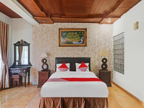 a bedroom with a large bed with red pillows at OYO Life 11350O Hotel R Cantika Syariah in Bangko