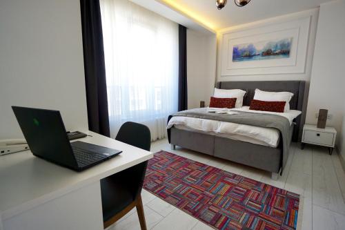 a bedroom with a bed and a desk with a laptop at Viva Suites Cappadocia in Nevşehir