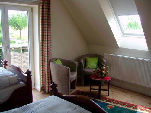 Zimmer im Dachgeschoss mit 2 Stühlen und einem Fenster in der Unterkunft Ferienhaus Anke in Heiligenhafen