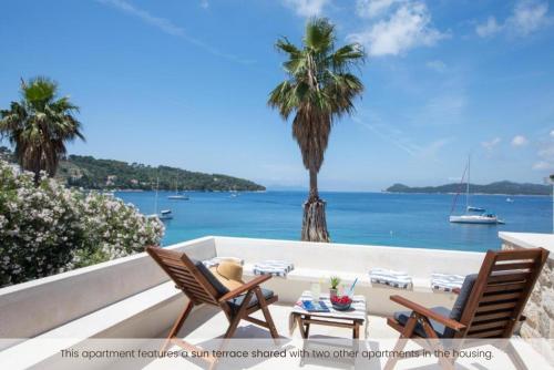 a patio with two chairs and a table and the ocean at The Little Prince in Lopud Island