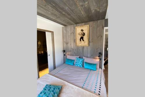 um quarto com uma cama com almofadas azuis em Le FLOCON du Mont Darbois classé 3 étoiles em Megève
