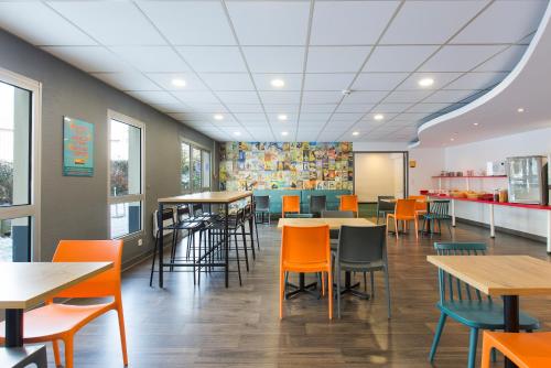 ein Essbereich mit Tischen und Stühlen in einem Restaurant in der Unterkunft hotelF1 Igny Massy TGV in Igny