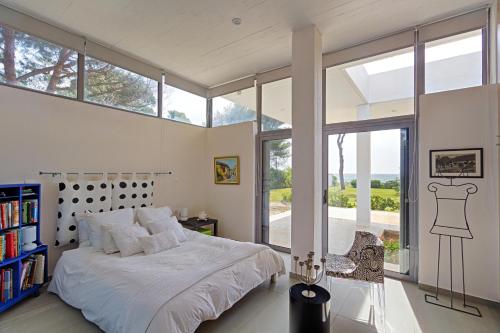 a bedroom with a bed and a large window at Seaside Villa Hoopoe just steps from the beach in Schinias
