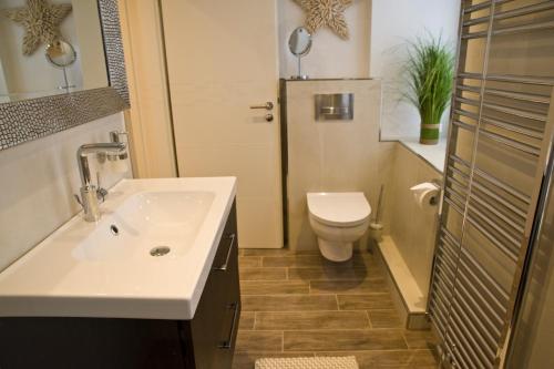łazienka z umywalką i toaletą w obiekcie Sunrise w mieście Grömitz
