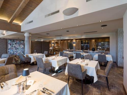 a dining room with white tables and chairs at Hotel & Spa Sonne 4 Sterne Superior in Kirchberg in Tirol