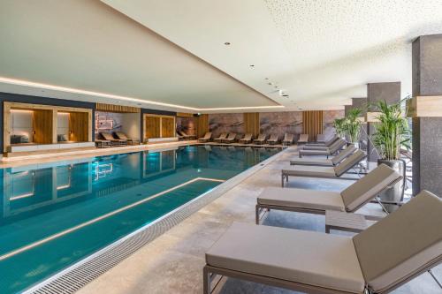 a swimming pool with lounge chairs in a hotel at Hotel & Spa Sonne 4 Sterne Superior in Kirchberg in Tirol