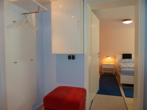 uma pequena sala com um banco vermelho e um quarto em Haus Carmesin em Eckernförde