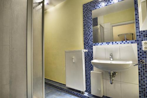 uma casa de banho com um lavatório e um espelho em Robbe FW 4 em Zingst