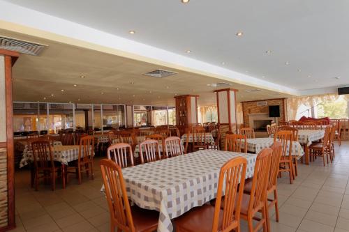 a dining room with tables and chairs in a restaurant at Hotel Pliska All inclusive in Golden Sands