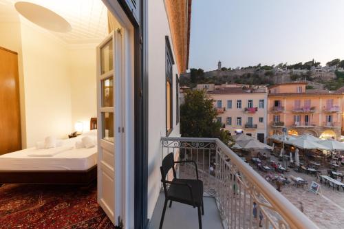 einen Balkon mit einem Bett und Stadtblick in der Unterkunft GRANDE CASTELLANO in Nafplio