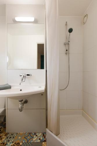 une salle de bain blanche avec un lavabo et une douche dans l'établissement hotelF1 Cergy, à Cergy