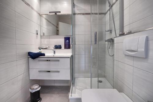 y baño con ducha, aseo y lavamanos. en Aparthotel "Am Kurhaus" 108, App Ostseeblick, en Zingst