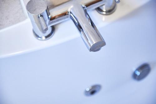 a bathroom sink with a chrome bathroom faucet at Penuwch Boathouse- Lakeside rural cottage ideal for families with indoor heated pool in Carmarthen