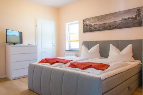 ヴァーレンにあるFerienwohnung am Mühlenbergのベッドルーム1室(大型ベッド1台、赤いタオル2枚付)