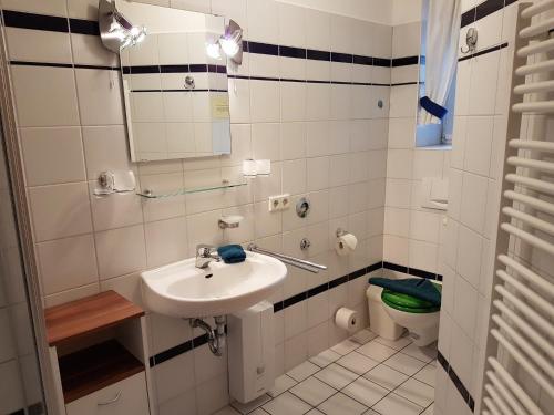 biała łazienka z umywalką i toaletą w obiekcie Haus Weidenhof App 1 w Prerowie