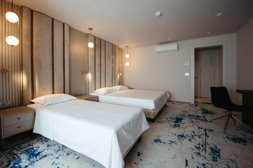 a hotel room with two beds and a desk at Pensiunea Iristar in Fălticeni