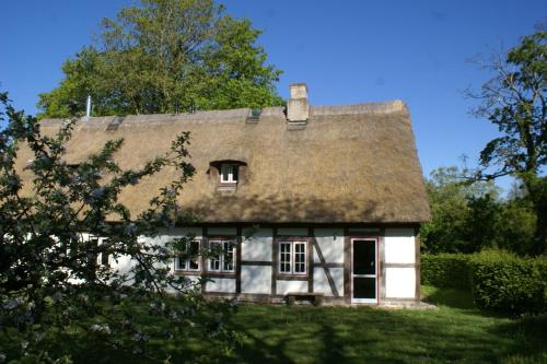 an old white house with a thatched roof at Kate Windeby in Windeby