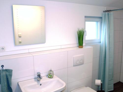 a bathroom with a sink and a toilet and a mirror at Exklusives Ferienhaus Hamburg West! in Hamburg