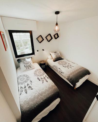 deux lits dans une petite pièce avec une fenêtre dans l'établissement Cap d'Agde appart. 4/6 pers. avec jardin, piscine., au Cap d'Agde