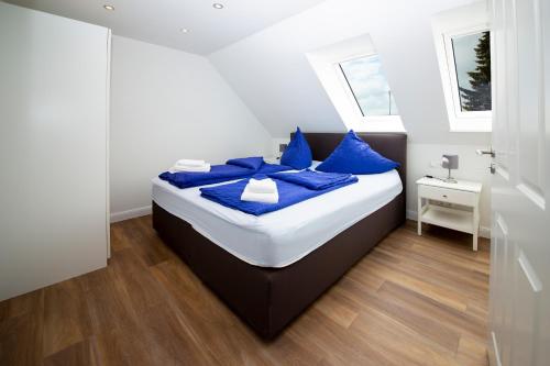 a bedroom with a bed with blue pillows at Appartement Schleipanorama in Rabenkirchen-Faulück