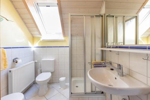 a bathroom with a sink and a toilet and a window at Ferienwohnung Säntisblick in Hergensweiler
