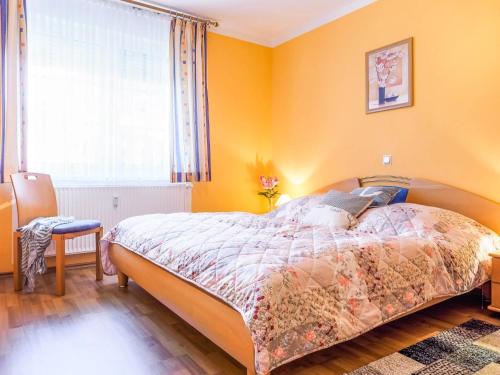a bedroom with a bed with orange walls and a window at Birkenstraße 6 Haus I Whg 1 in Zingst