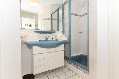 a bathroom with a blue sink and a shower at Haus Bornholm Whg 04 in Nieblum