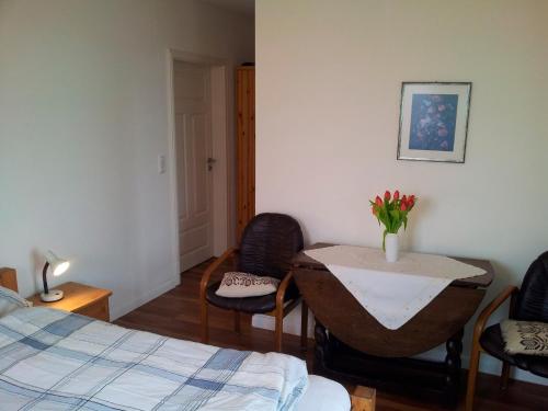 Un dormitorio con una mesa con un jarrón de flores. en "Höper Mittelhof" Doppelzimmer Nr4, en Lemkendorf