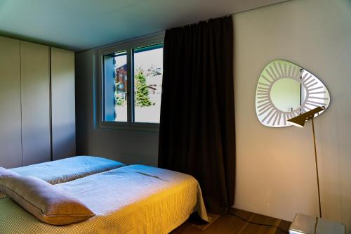 a bedroom with a bed and a mirror and a window at Mitti in Arosa