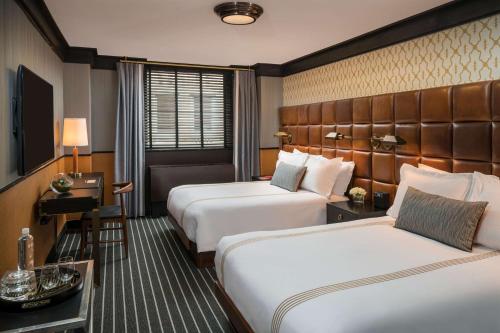 a hotel room with two beds and a desk at Gild Hall, A Thompson Hotel, by Hyatt in New York