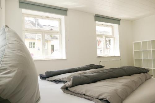 three pillows are lined up in a room with two windows at Ferienwohnung Neu "Zum Westerwald" LAHN01 in Löhnberg