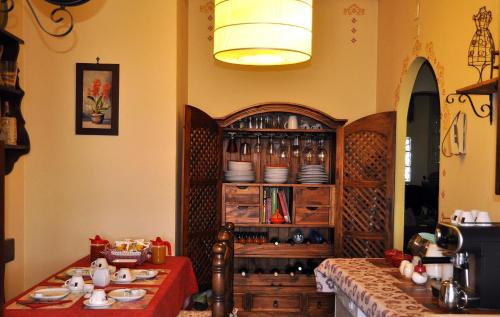 a dining room with a table and a cabinet with dishes at Bed and Breakfast Roma in Mostacciano