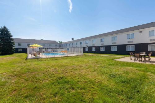 a building with a yard with a pool and picnic tables at Days Inn by Wyndham Sandusky Cedar Point in Sandusky