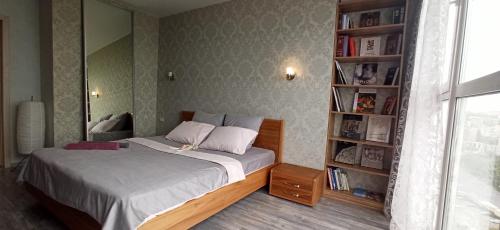 a bedroom with a bed and a book shelf at Квартира в Академ Риверсайд с панорамным видом in Chelyabinsk