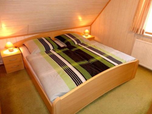 CranzahlにあるFerienhaus Karinのベッド1台(ナイトスタンド2台付)が備わる小さな部屋です。