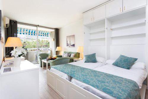 プエルト・デ・ラ・クルスにあるApartment 327 im Precise Resort Tenerifeのベッドルーム(青い枕の大型ベッド1台付)