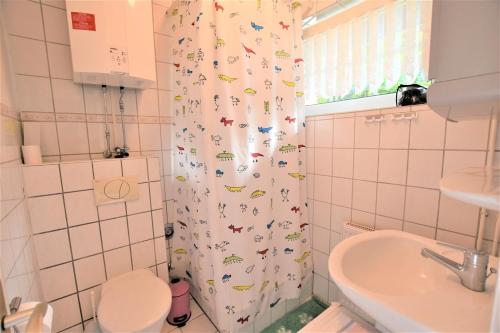 a bathroom with a shower curtain with animals on it at Haus Antje-Kellenhusen Whg3 in Kellenhusen